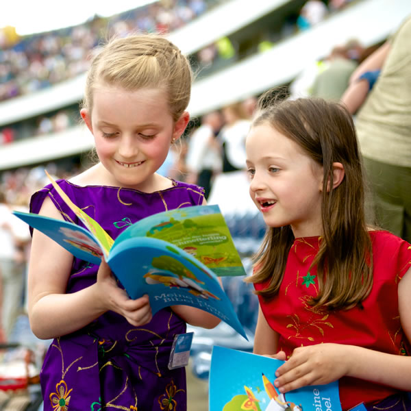 A un congresso due bambine sfogliano l’opuscolo La Bibbia anche per me