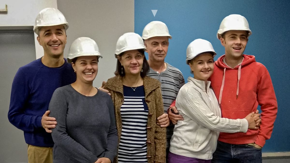 Oleh e i suoi familiari con i caschetti antinfortunistici nel cantiere di una Sala del Regno.