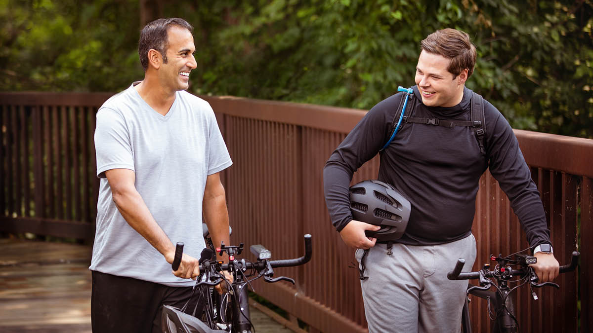 L’anziano e il fratello sorridono mentre trascorrono del tempo insieme in bicicletta.