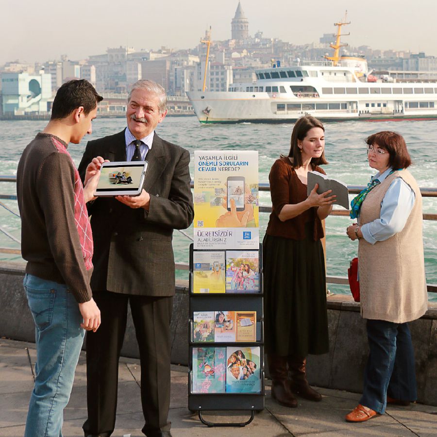 Testimoni di Geova svolgono la testimonianza pubblica con un espositore mobile