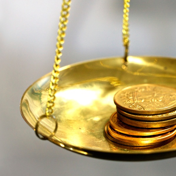 金貨がはかりにかけられている