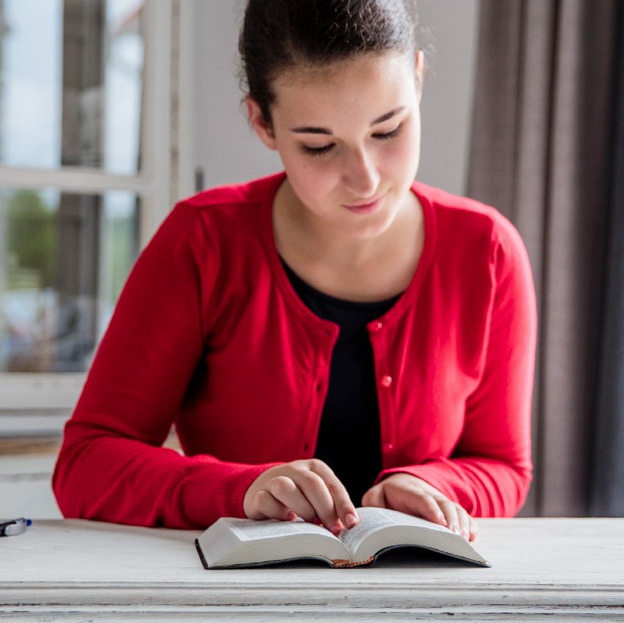 10代の少女が聖書を読んでいる