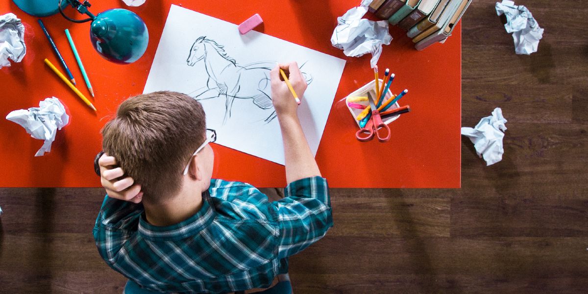 10代の男の子が完璧な馬の絵を描こうと何度も試みている。
