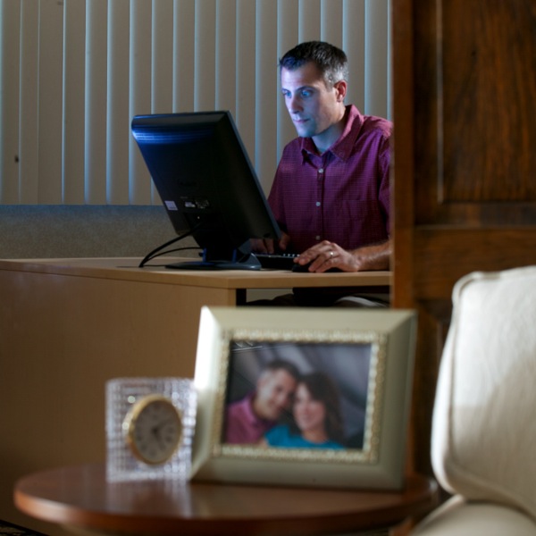 深夜にコンピューターでインターネットを使用している既婚の男性