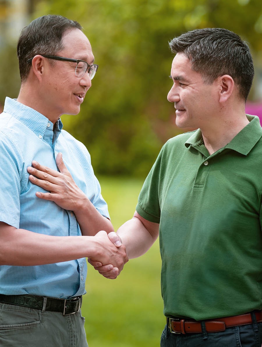 写真1: 2人の姉妹が王国会館で話し合っている。写真2: 2人の兄弟が握手している。