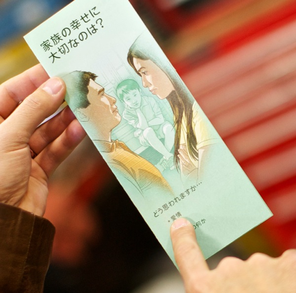 一人のエホバの証人が，「家族の幸せに大切なのは？」のパンフレットを用いて証言している