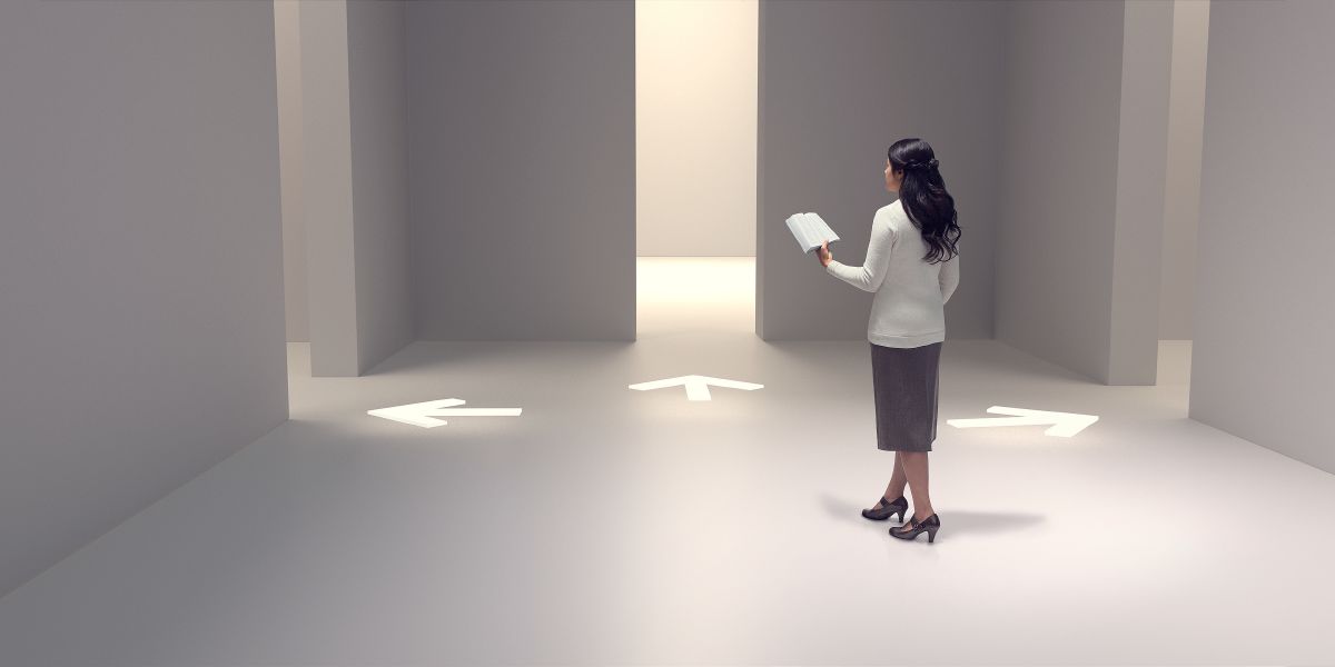 女性が聖書を手に持ち，どの道に進むかを考えている