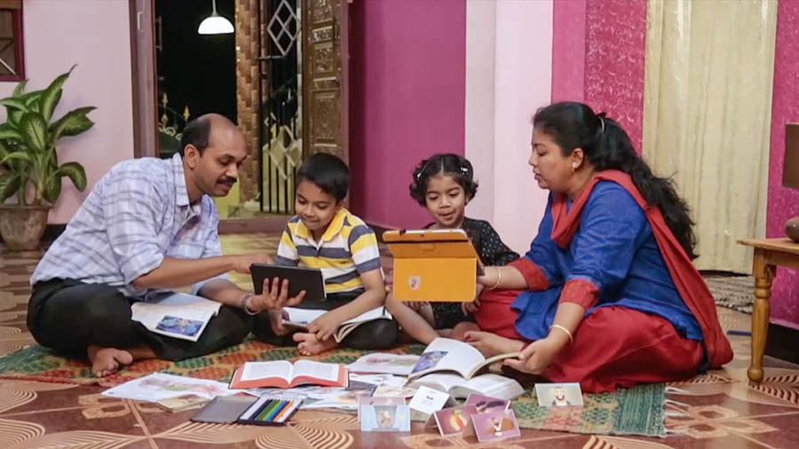 Adegan saka vidéo ’Mbangun Omah sing Kokoh—Jaganen Anak-anakmu saka ’Perkara-Perkara sing Ala.’’ Wong tuwa ngrembug buku ’Belajarlah dari sang Guru Agung’ lan buku-buku liyané bareng karo anaké loro.