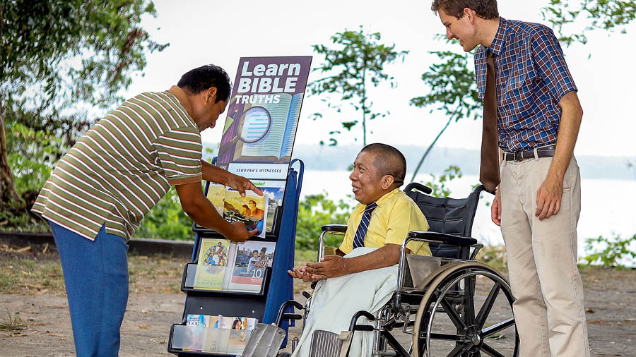 Mark Herman aikarĩire wheelchair hakuhĩ na gakaari ka mabuku akĩhunjĩria mũndũ.