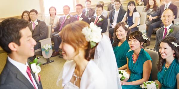 회중 사람들이 지켜보는 가운데 신랑과 신부가 결혼 서약을 하는 모습