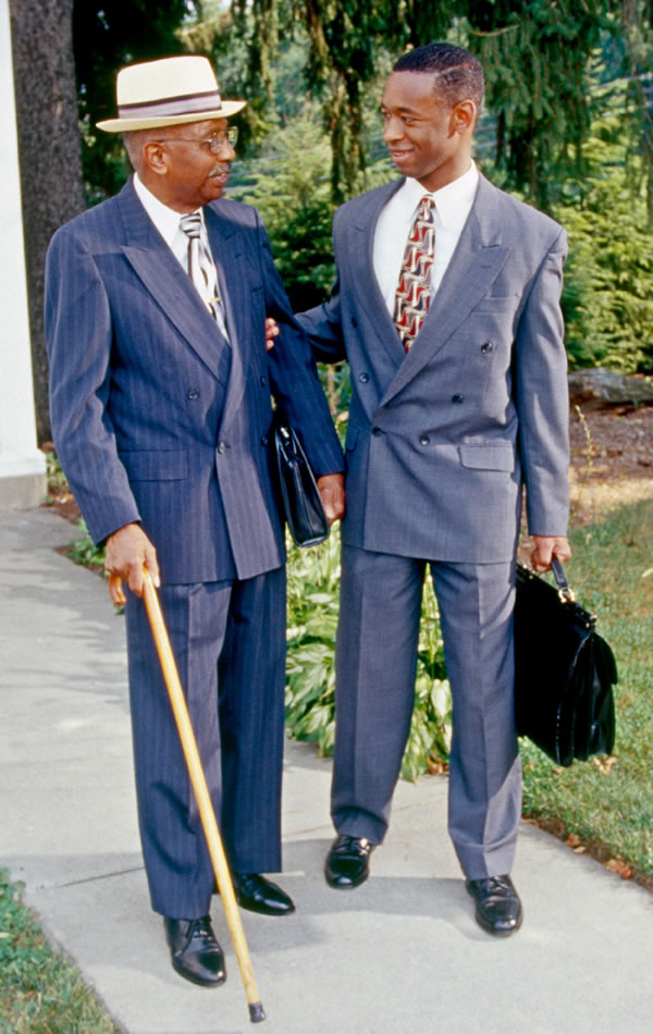 A young Witness happily assisting an elderly Witness in the public ministry work