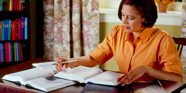A woman studying the Bible and Bible-based publications to acquire godly wisdom