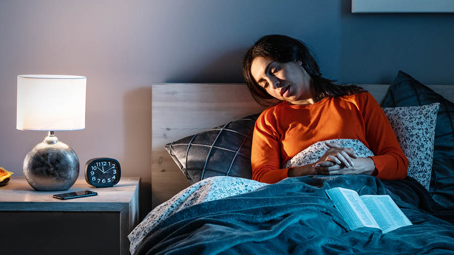 Dans son lit, une sœur s’endort alors qu’elle est en train de prier.