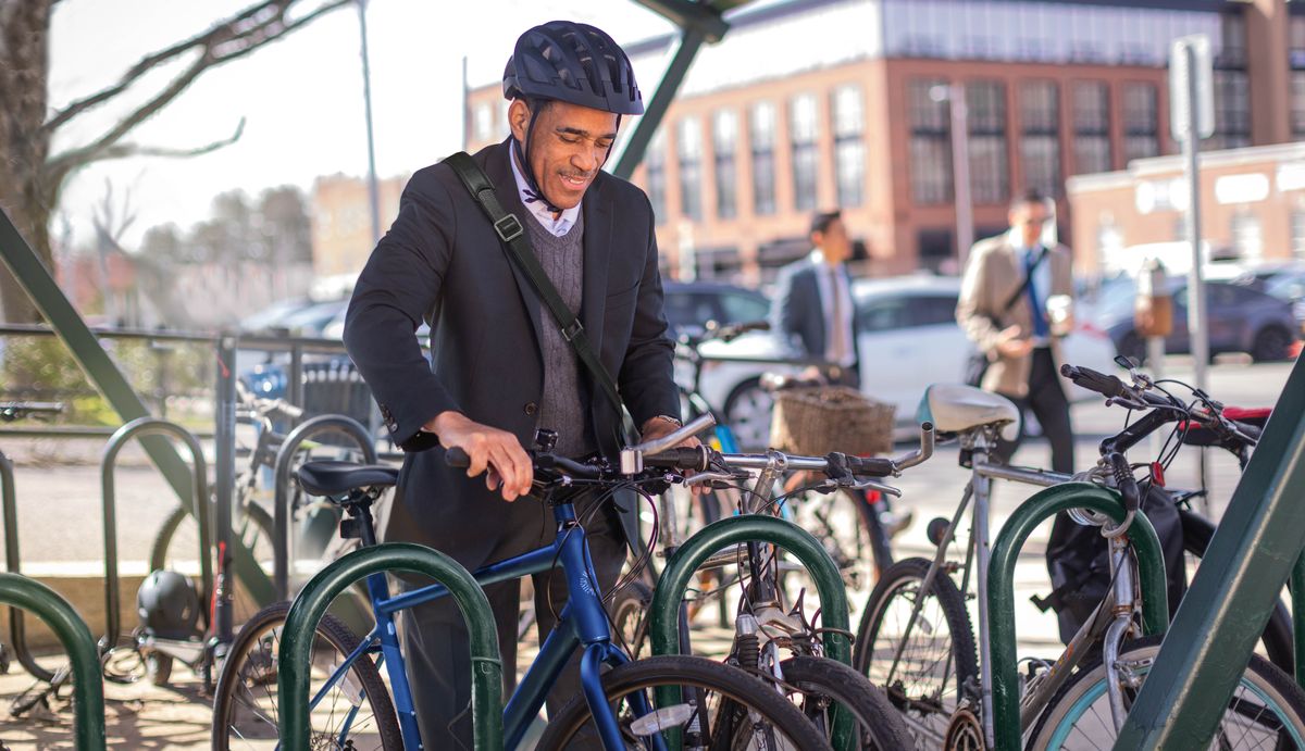 Mobali moko auti mosala na velo, mpe azali kotya velo yango na parking.