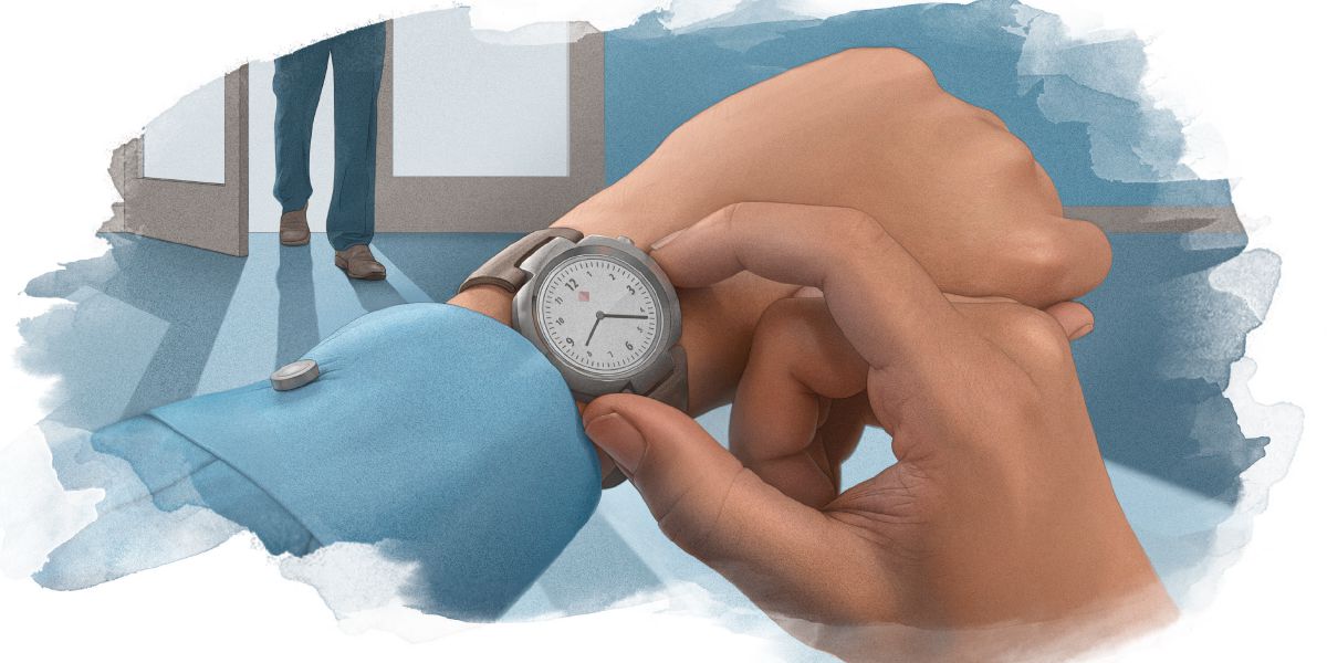 Vienas vyras žiūri į laikrodį, kai kitas įeina į kambarį