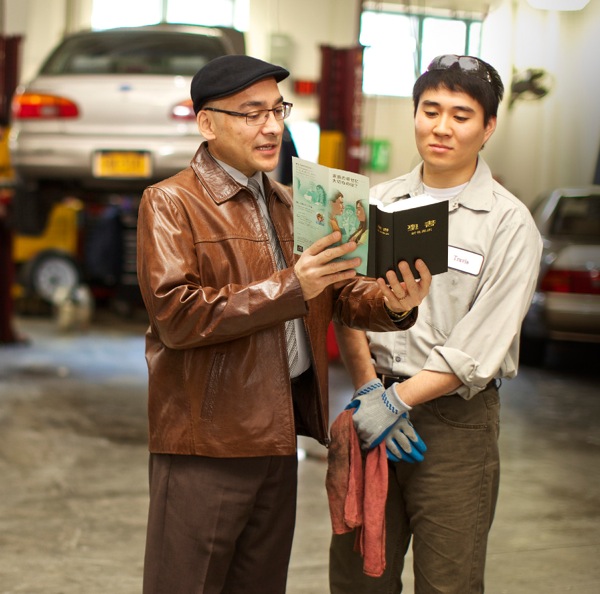 One of Jehovah’s Witnesses reading a Bible verse to a young man