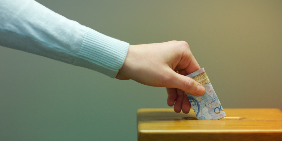 A person puts a donation in a contribution box