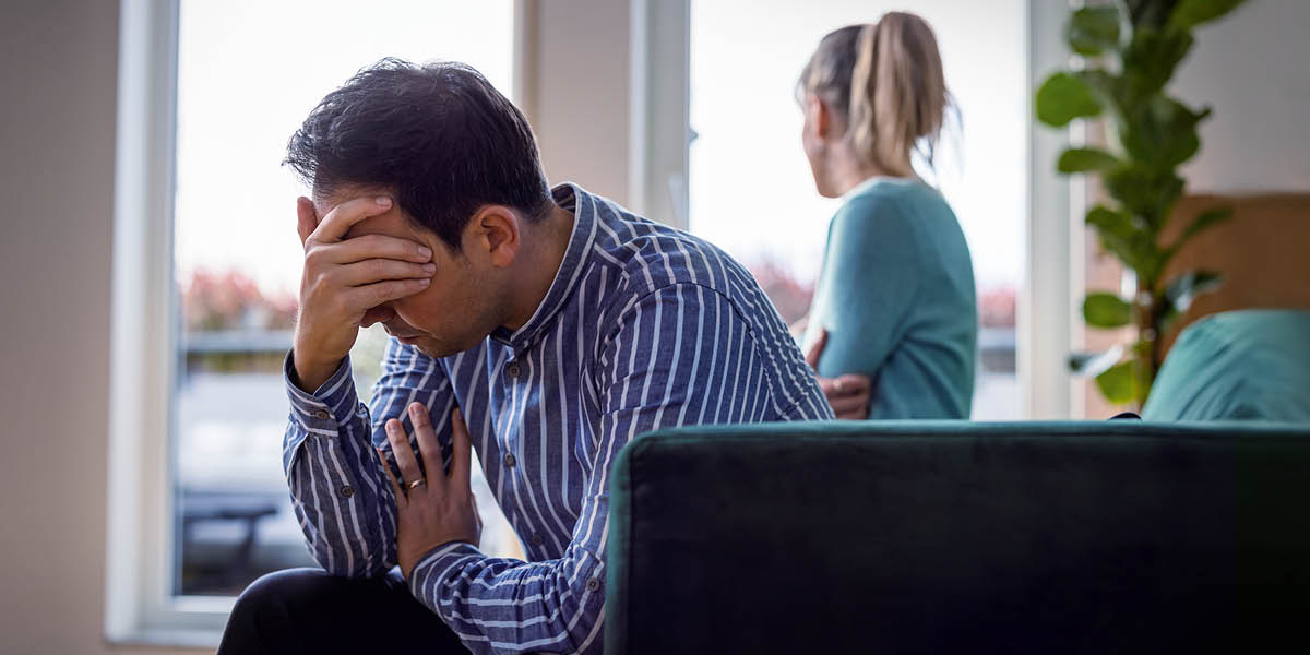 Еден потиштен и посрамен сопруг се држи за глава со раката, а неговата сопруга разочарано гледа низ прозорецот.