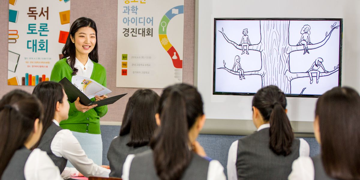 Guidance teacher fil-Korea t’Isfel turi vidjow minn fuq il-Websajt jw.org lill-istudenti tagħha