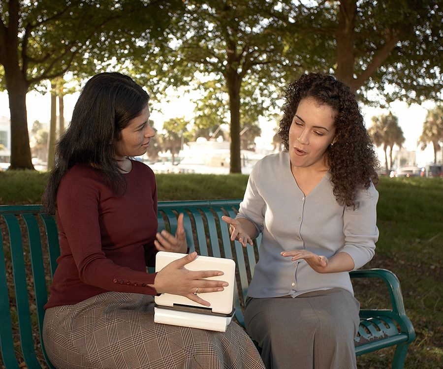 One of Jehovah’s Witnesses reads a scripture to a woman