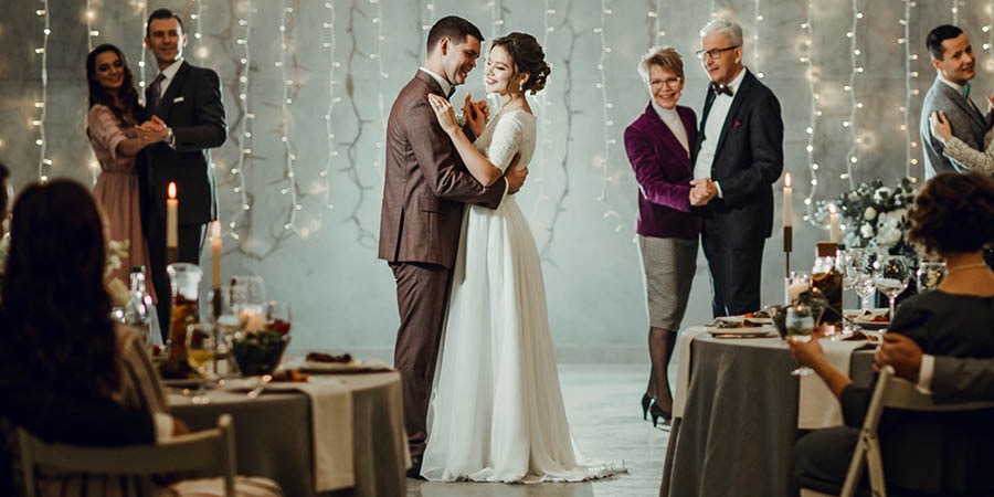A noiva e o noivo dançam na festa de casamento, juntamente com alguns dos convidados.