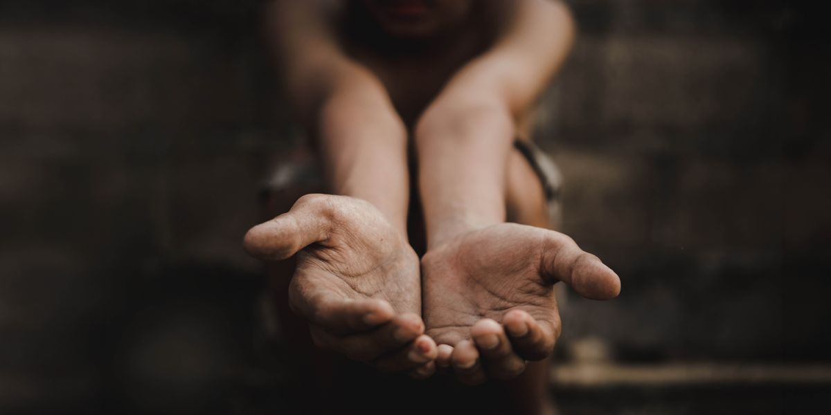 Uma pessoa a pedir com as mãos estendidas.