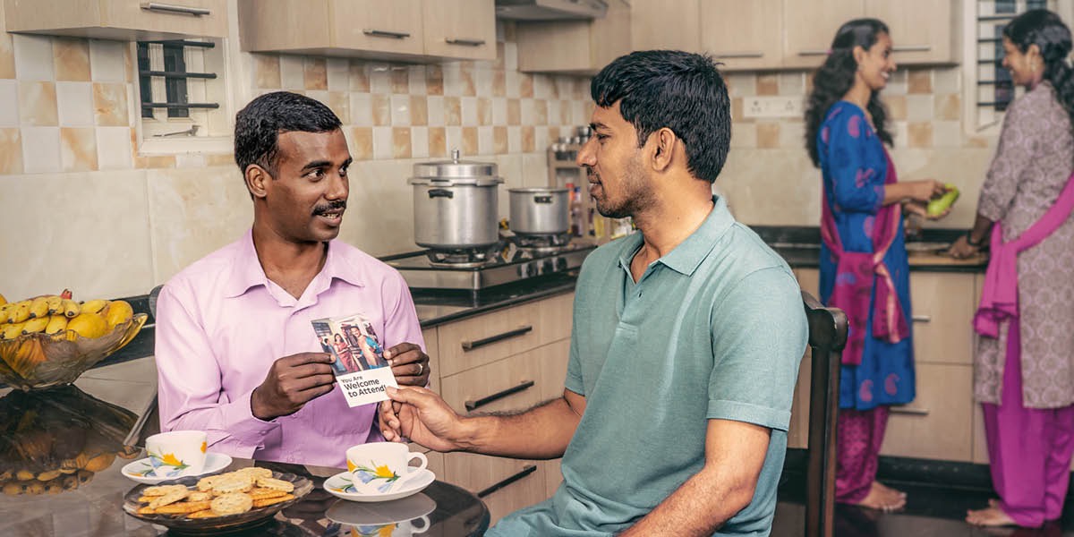 एक भाइ आफ्नो आफन्तलाई खाजा खाँदै गर्दा स्मरणार्थको निम्तो दिँदै छन्‌। तिनीहरूका पत्नीहरू पछाडि कुरा गर्दै र खाना बनाउँदै छन्‌।