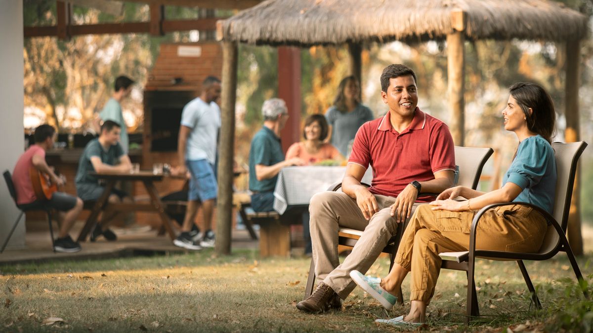 डेटिङ गरिरहेको एउटा जोडी एउटा जमघटमा छुट्टै बसेर कुराकानी गर्दै छ।