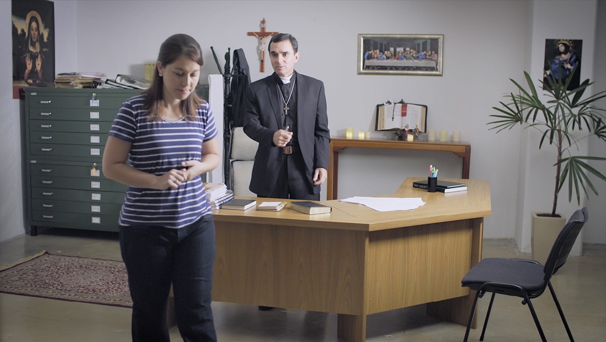 Een scène uit de video ‘Ga weg uit Babylon de Grote!’ Een Bijbelstudent loopt weg bij een priester nadat ze haar baan bij een kerk heeft opgezegd.