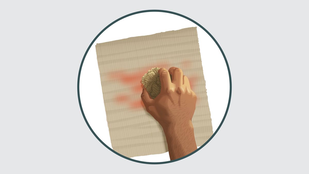 Een hand wist met een spons de tekst op een vel papier uit.