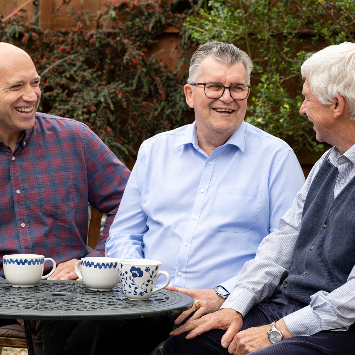 Kevin drinkt koffie samen met twee vrienden.