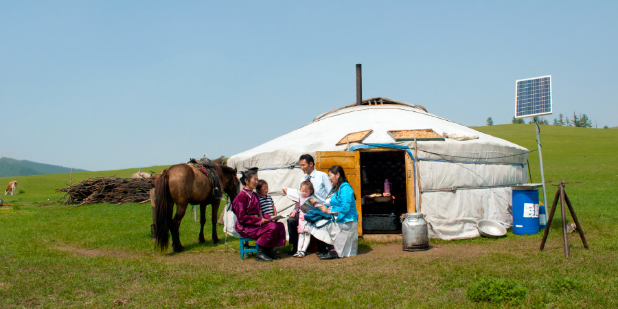 Noen mongoler utenfor en typisk, rund jurt