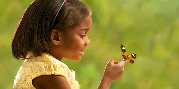 A girl, a living soul, looking at a butterfly, another living soul