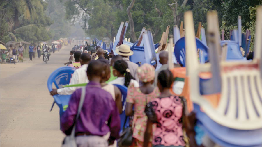 Bzinthu bzomwe bzikucitika mu vidiyo ya msolo wakuti ‘Lufoyi Lanu Lireke Kumala . . . Penu Munkugumana na Bvuto la Kobiri—ku Kongo.’ Mthithi wa abale ukuyenda ku mbuto yomwe imbacitikira mitsonkhano ya cigawo. Azinji adanyamula makadera na bzinthu bzinango.