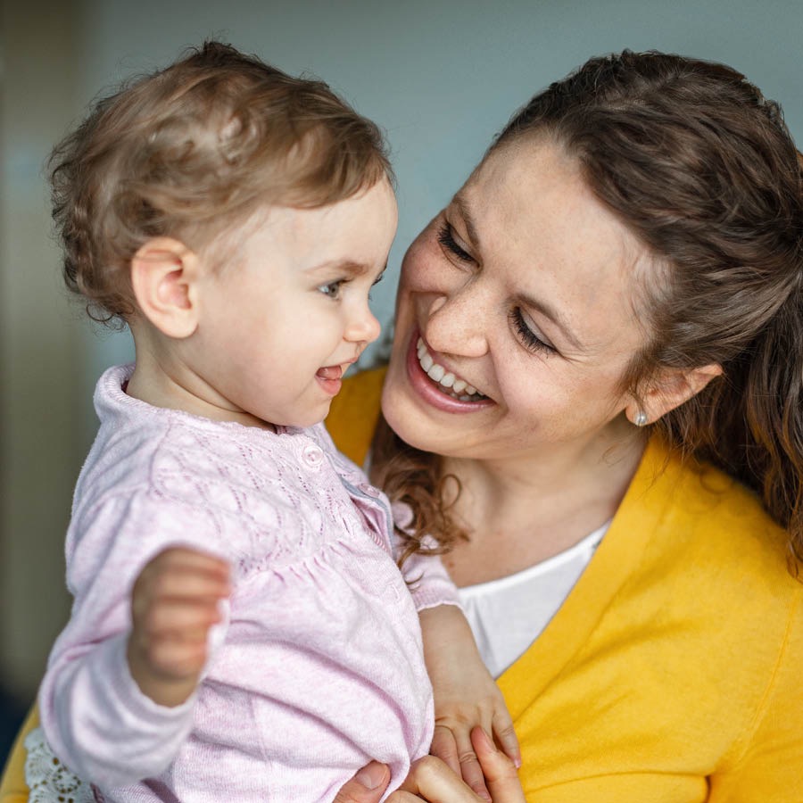 Un mama tin su bebi den su brasa karga