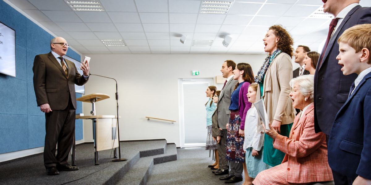 Young people and old people dey sing for Kingdom Hall