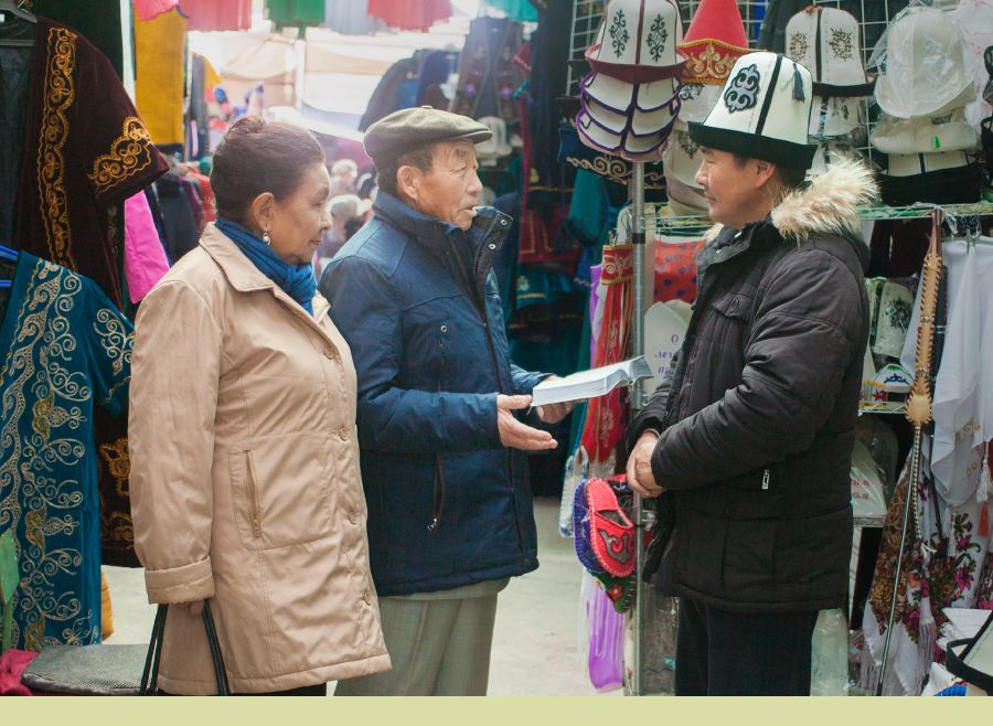 Beishenbai Berdibaev and im wife dey preach to one man wey dey sell for store