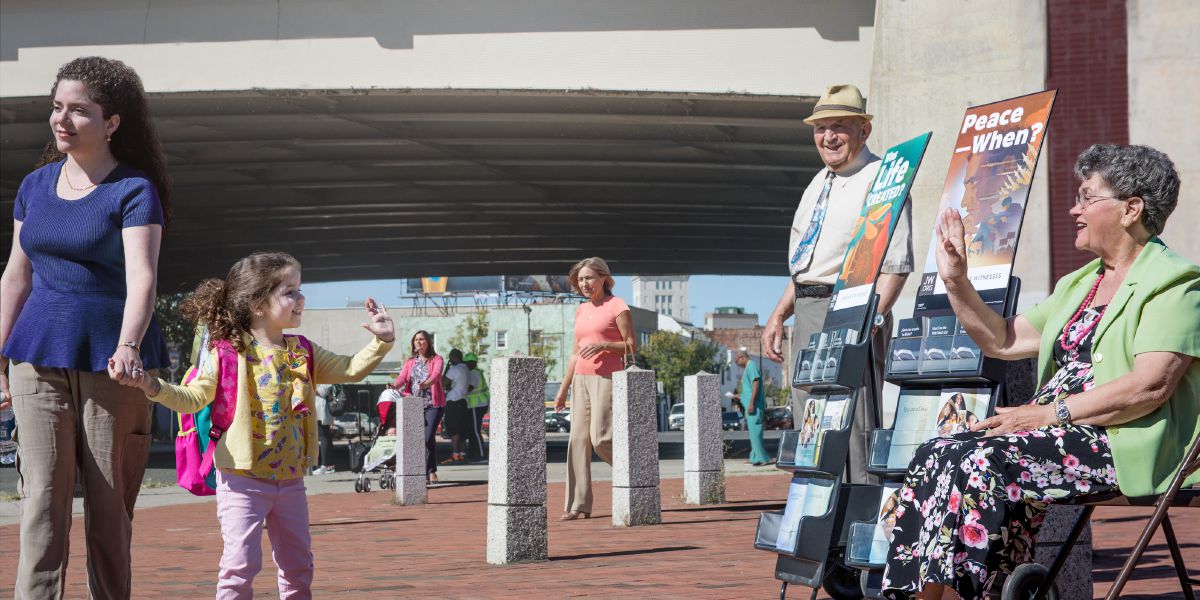 Sergio and Olinda de preach with our books to people wey them de pass, near one bus stop