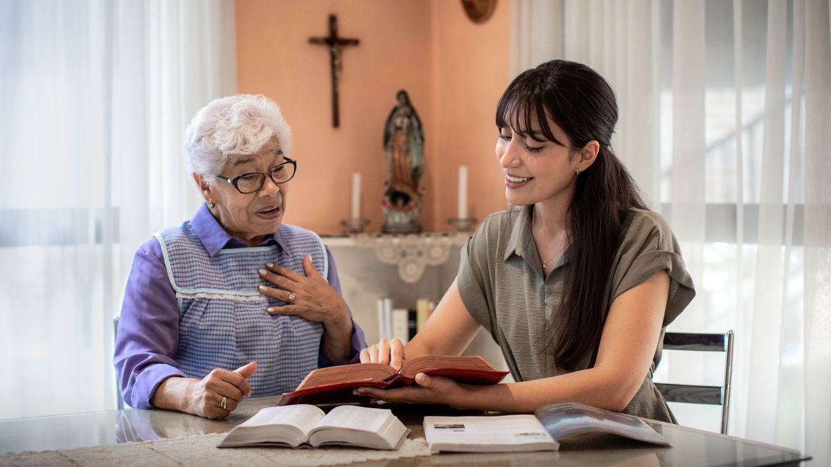 Eene Sesta studieet met eene elre Fru de Bibel. De elre Fru haft een Kjriez aune Waunt henjen un eenen Aufgott oppem Desch stonen. De Fru es gaunz vewundat, aus see Jehowa sienen Nomen en äare ieejne Bibel sitt.