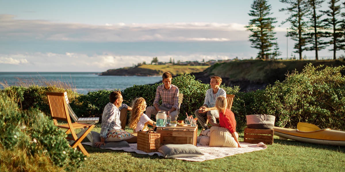 Wanfala famili picnic saed lo river. Olketa laflaf and enjoyim taem tugeta.