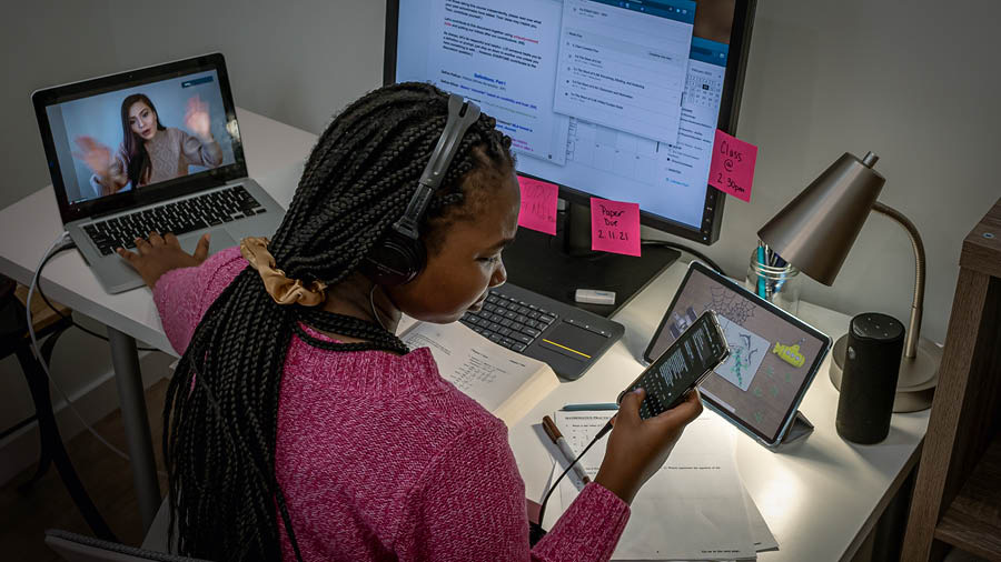 Wanfala teenage gele hem duim tu-thri samting lo semtaem. Hem typem wanfala text message lo smartphone blo hem, video chat witim wanfala fren, and iusim wanfala computer and textbuk for study.