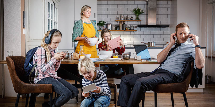 Wanfala mami wea redyim breakfast lo tebol hem luk kros taem hasband and olketa pikinini gohed busy lo olketa electronic device.