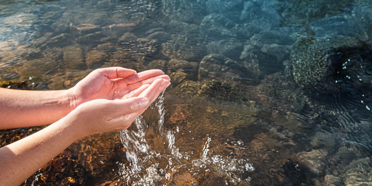 Wanfala woman holem klin wata insaed hand blo hem from wanfala stream.