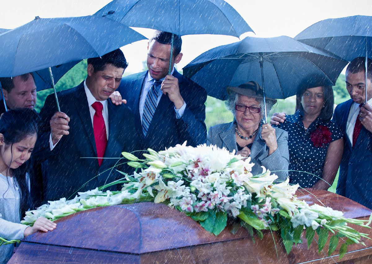 Wanfala famili wea sorre tumas standap raonem coffin wea olketa putim flaoa antap