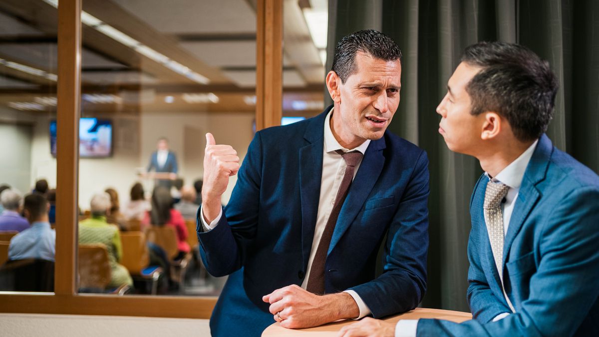 Tufala brata story tugeta during wanfala kongregeson meeting. Feis blo wanfala brata hem luk olsem hem komplen and hem point go lo nara brata wea gohed givim tok.