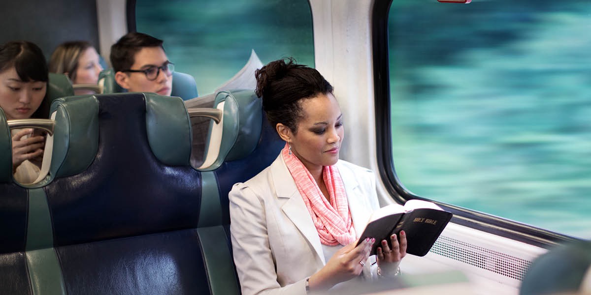 Wanfala woman insaed train readim Bible