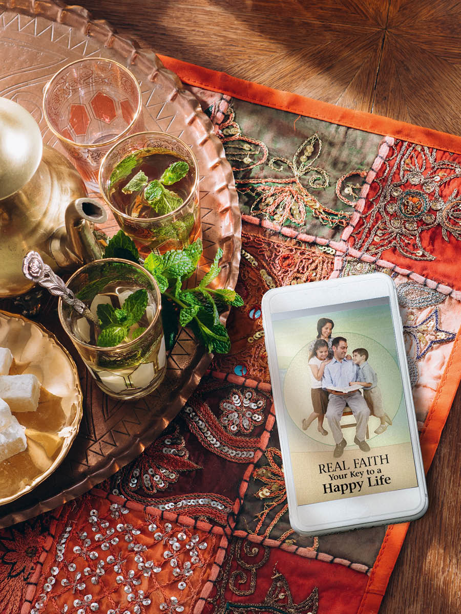 Wanfala mobile stap saed lo tufala kap coffee. Piksa blo datfala brochure ‘Real Faith​—⁠Your Key to a Happy Life’ nao insaed lo datfala mobile.