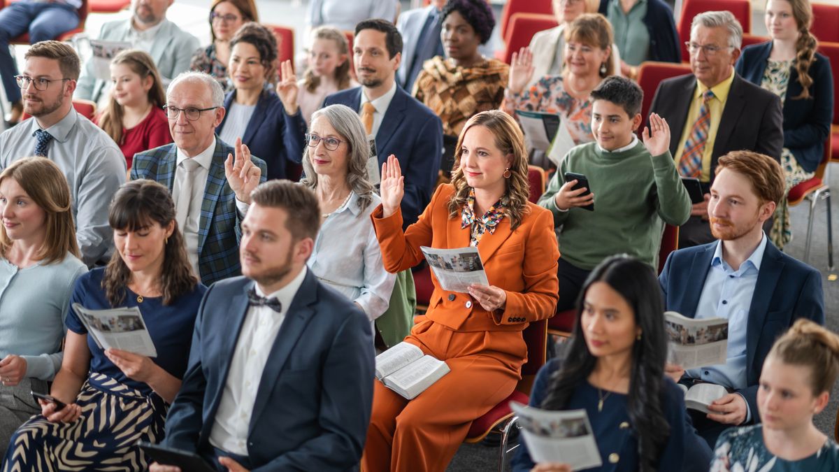 Siostra zgłasza się do odpowiedzi podczas studium „Strażnicy”. Inni bracia i siostry też się zgłaszają.