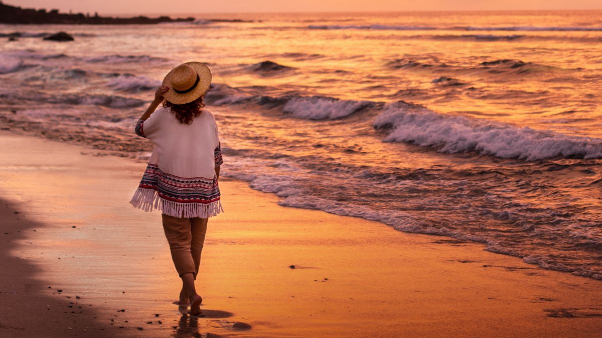 Un irma sta na pasia na praia oca ku sol na kai.
