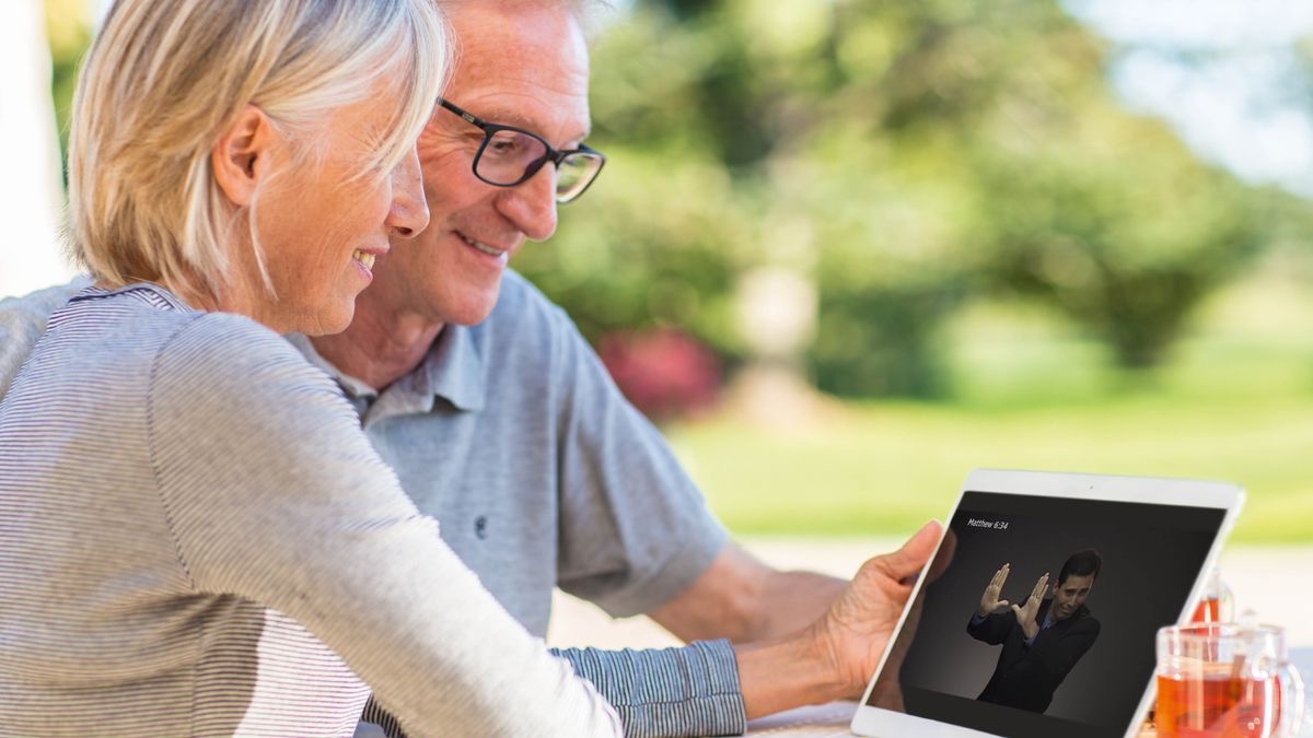 Siostra w słuchawkach słucha nagrania z tabletu.
